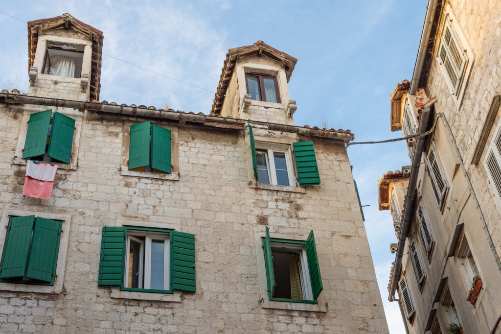 The green shuttered windows of houses inside the ancient Diocletain's Palace in the centre of Split, Croatia.