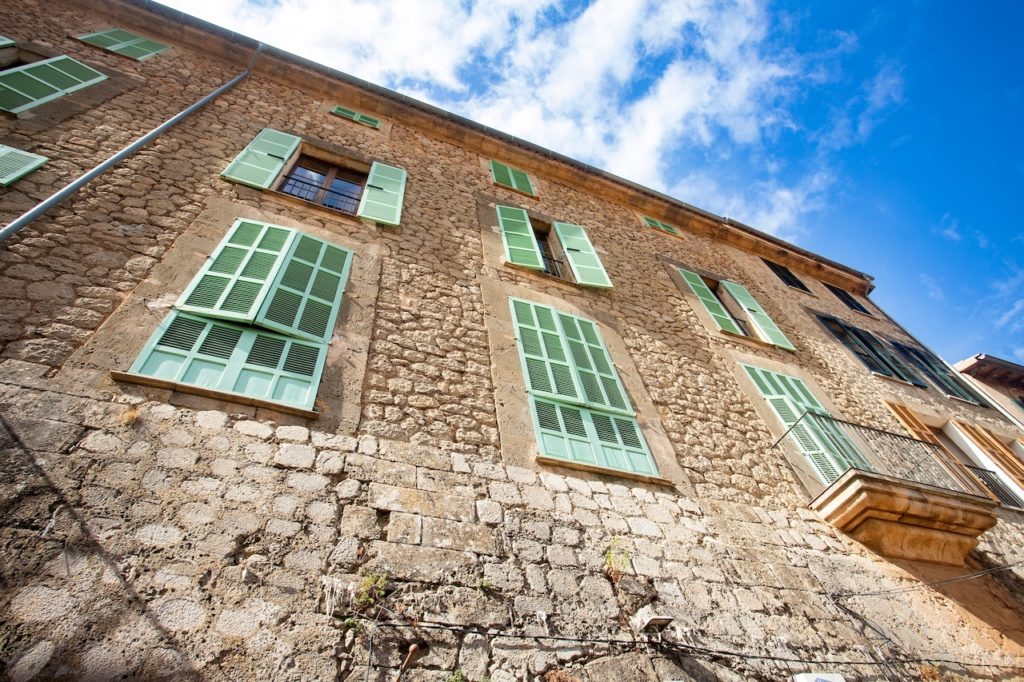 Valldemossa, Palma de Mallorca - Spain. September 26, 2022. Its stone houses decorated with colorful plants and green shutters have maintained the traditional flavor