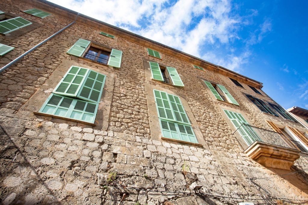 Valldemossa, Palma de Mallorca - Spain. September 26, 2022. Its stone houses decorated with colorful plants and green shutters have maintained the traditional flavor